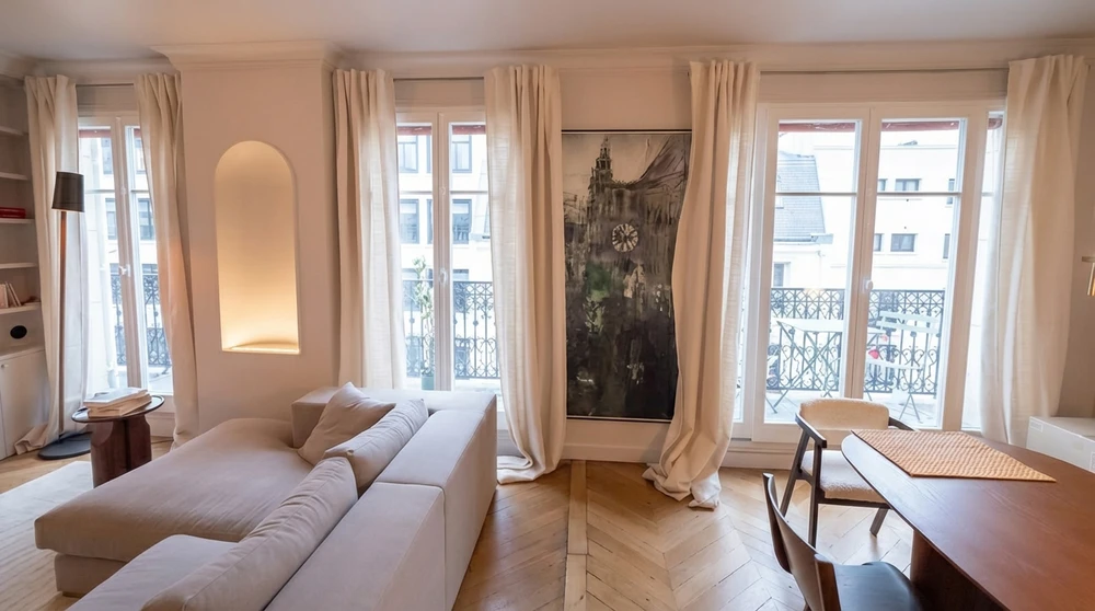 Un ouvrier en salopette et casquette installe une fenêtre dans un appartement moderne