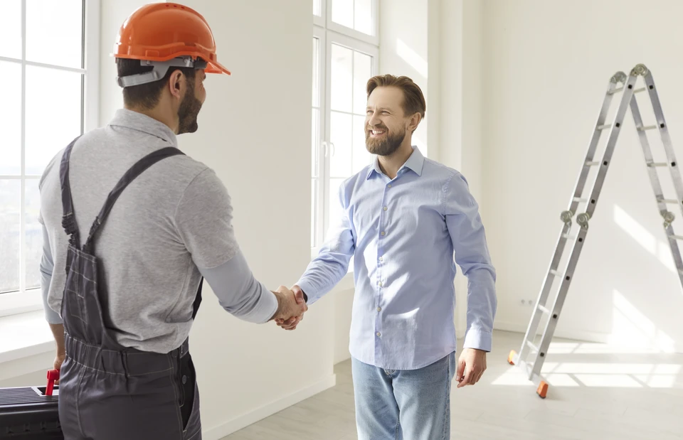 Professionnel en costume consultant des plans architecturaux sur tablette numérique et documents papier