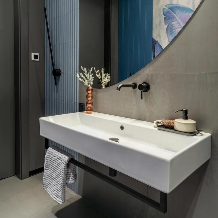 Salle de bain mansard&eacute;e en cours de r&eacute;novation avec carrelage m&eacute;tro blanc partiellement pos&eacute;, radiateur s&egrave;che-serviettes, sanitaires WC et bidet install&eacute;s
